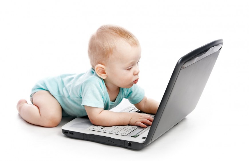 Bebé frente a laptop, tecnología en infantes