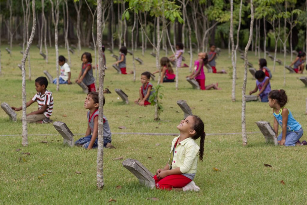 Niños frente a la representación de la muerte de árboles