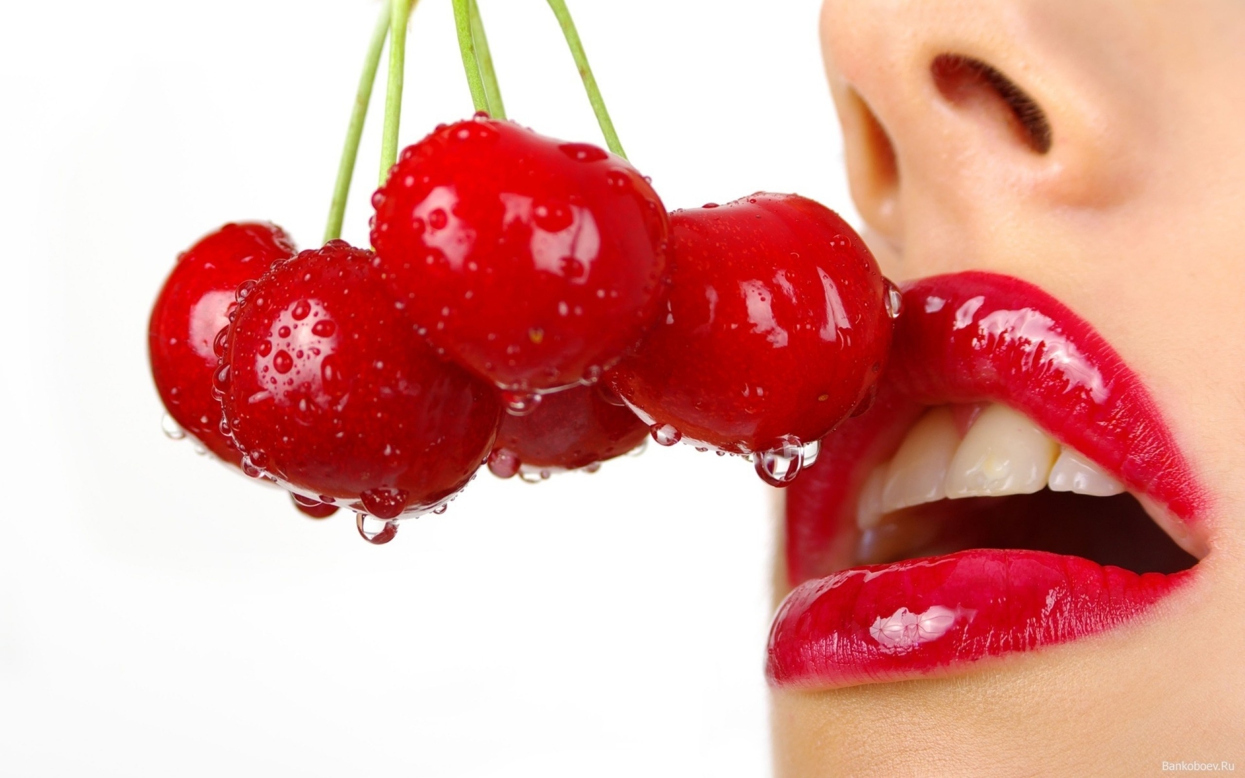 Labios rojos, cerezas tocando boca, mujer comiendo cerezas