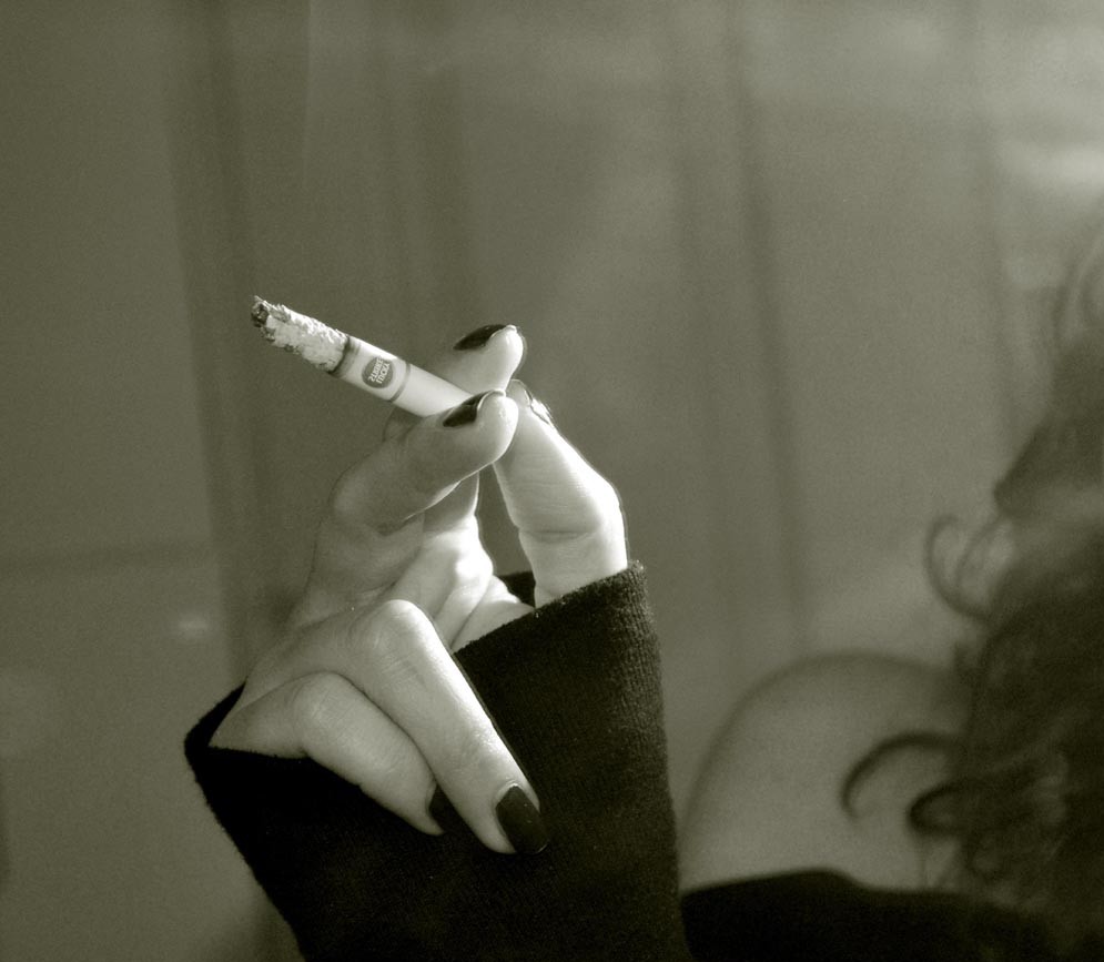 Mano femenina sostiene cigarrillo