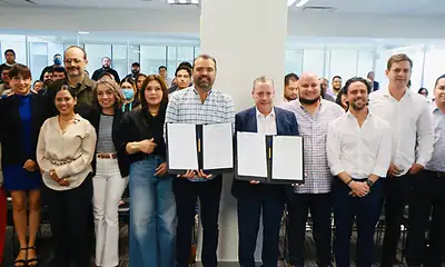 Firmantes de acuerdo en evento corporativo en oficinas de Siker, mostrando compromiso empresarial.