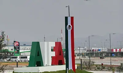 Fábrica de energía en México con señalización de PEMEX y bandera nacional mexicana.