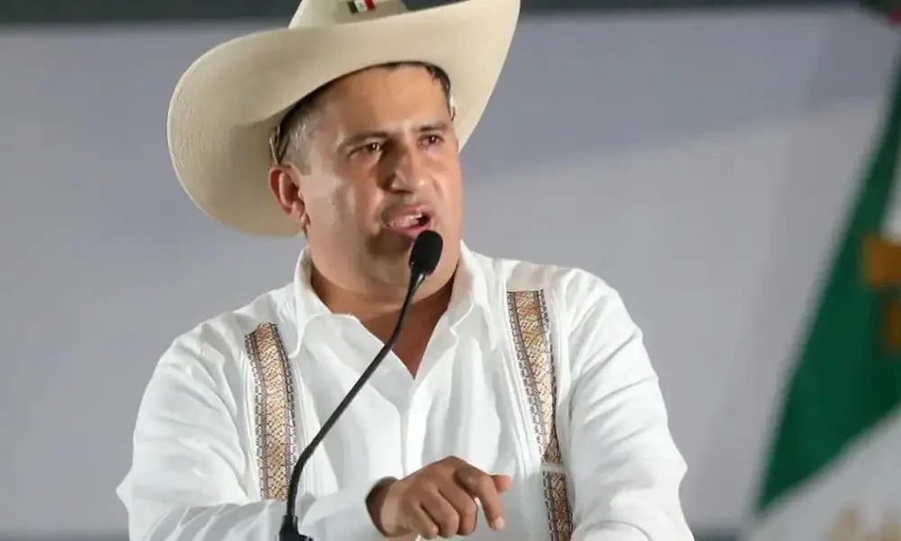 Hombre político en conferencia con sombrero mexicano en escenario.