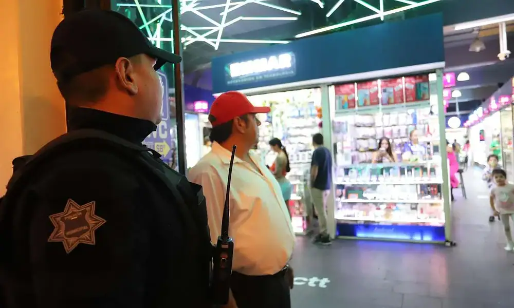 Vigilante de seguridad en shopping center con luces de neón.