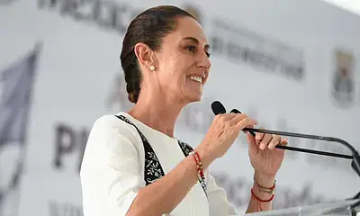 Primera mujer en el podio de un evento político de Siker, hablando con confianza y liderazgo.