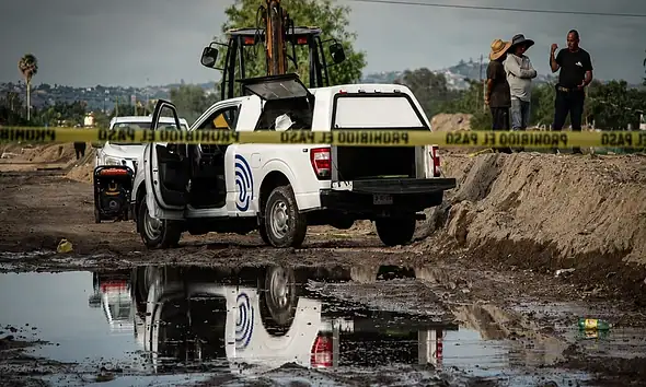 Bomberos de Tlajomulco trabajan en el canal de Las Pintas donde fue localizado el cuerpo de un hombre.