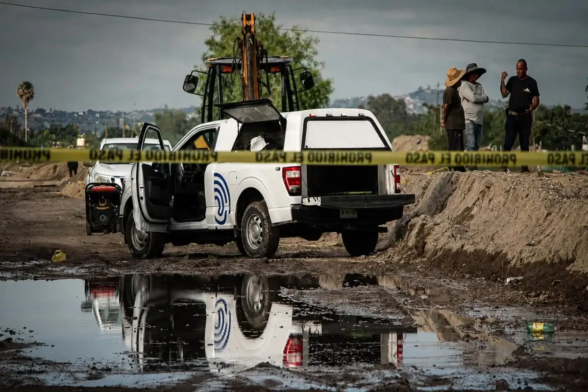 Bomberos de Tlajomulco trabajan en el canal de Las Pintas donde fue localizado el cuerpo de un hombre.