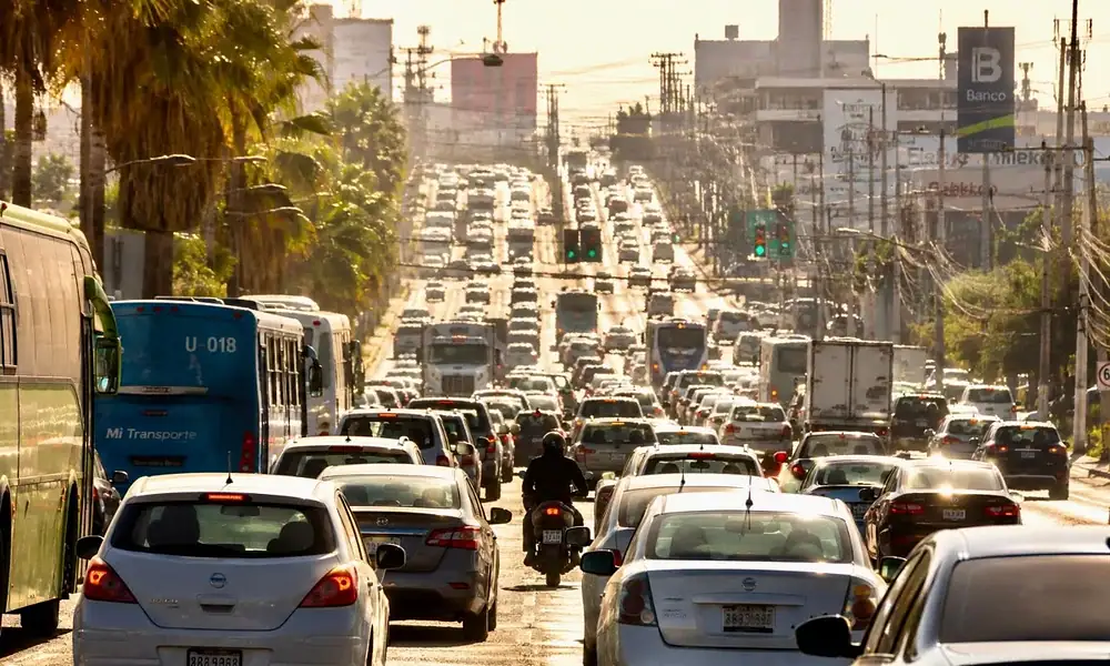 Vehículos circulan por una avenida de Jalisco durante el programa de descuentos para regularizar adeudos.