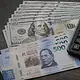 Billetes de dólares estadounidenses junto a pesos mexicanos durante una jornada marcada por la decisión de Banxico.