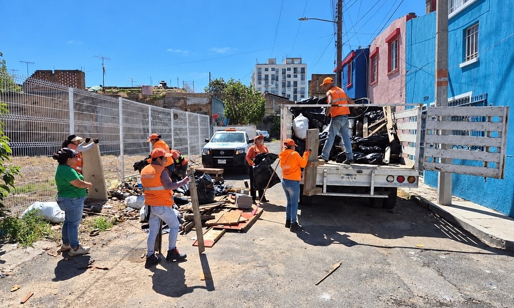 Personal de Guadalajara Limpia retira basura y objetos acumulados durante un operativo de limpieza en la vía pública.