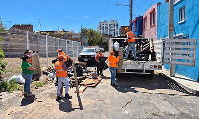Personal de Guadalajara Limpia retira basura y objetos acumulados durante un operativo de limpieza en la vía pública.
