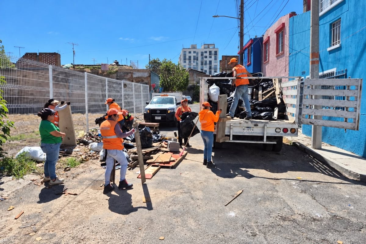 Personal de Guadalajara Limpia retira basura y objetos acumulados durante un operativo de limpieza en la vía pública.